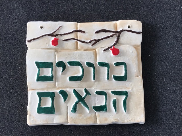 Hebrew welcome plaque with pomegranate branch