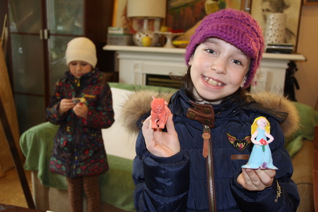 Young student holding clay figurines