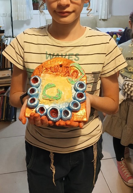 Young student holding a painted hamsa