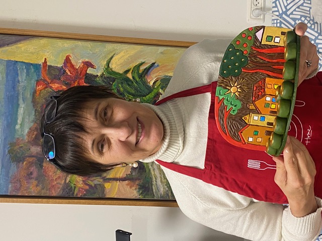 Student holding painted landscape scene